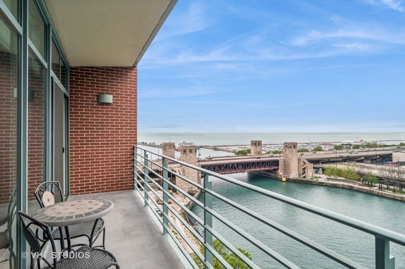 Balcony with a view over a river and a bridge.