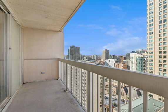 View of surrounding buildings from a balcony in a high-rise building.