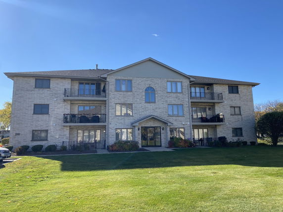 Front view of a three-story apartment building with balconies.