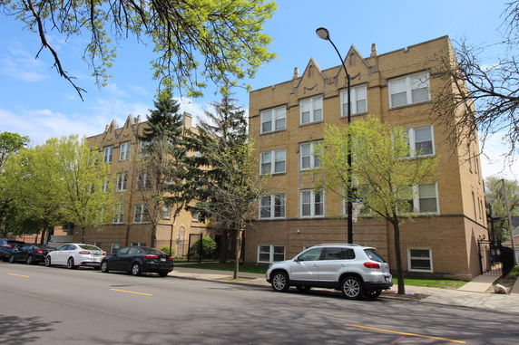 Front view of a three-story apartment building with multiple windows.