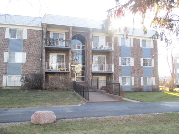 Front view of a three-story apartment building with balconies.