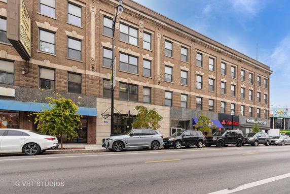 Front view of a multi-story commercial building with shops on the ground floor.
