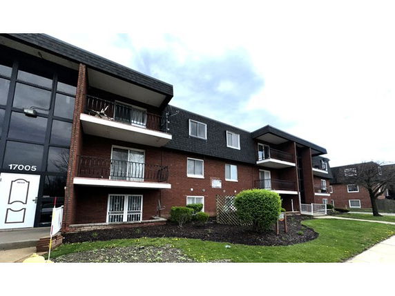Front view of a multi-story apartment building with balconies.