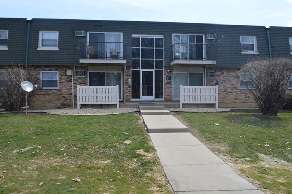 Front view of a two-story building with balconies and a central entrance.