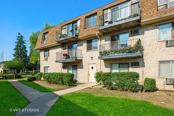 Front view of a three-story apartment building with balconies.