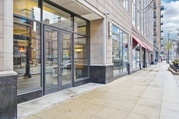 Front view of a multi-story commercial building with large glass doors and windows.