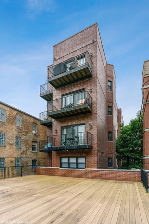 Front view of a multi-story brick building with balconies.