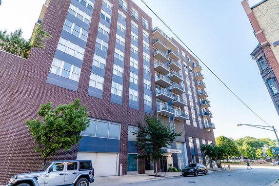 Front view of a multi-story apartment building with balconies.