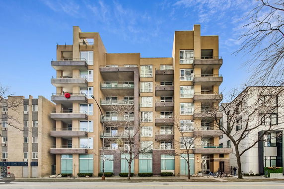 Front view of a multi-story apartment building with balconies.