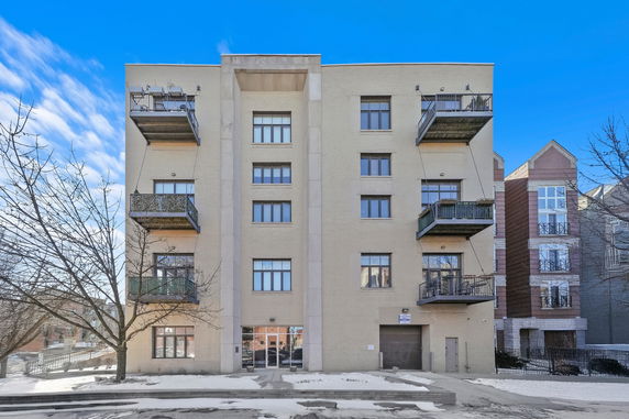 Front view of a multi-story apartment building with balconies.