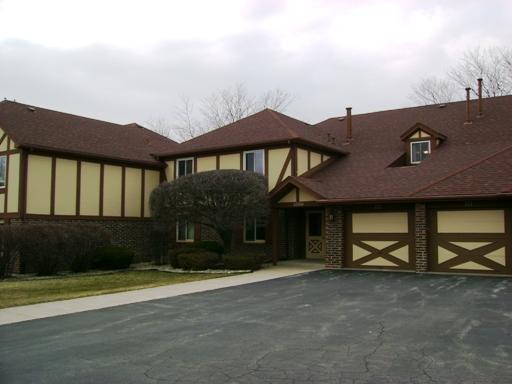 Front view of a two-story house with a double garage and Tudor-style architecture.