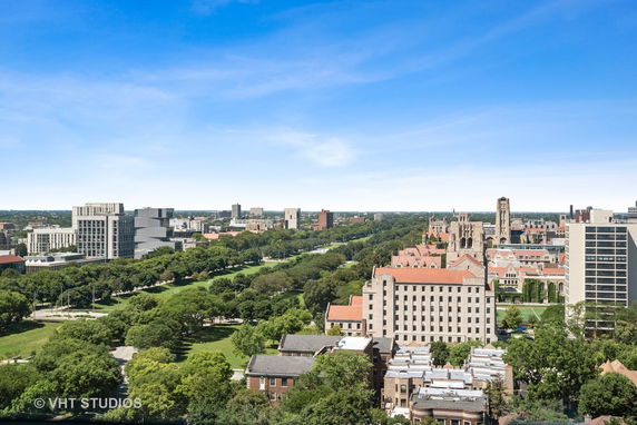 Wide-angle view of an urban landscape with various buildings and greenery.