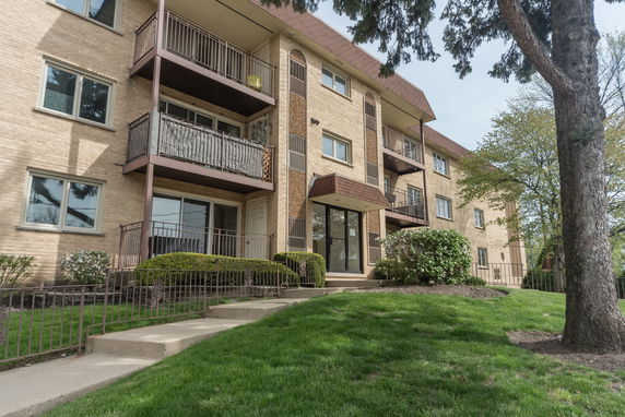Front view of a multi-story apartment building with balconies.