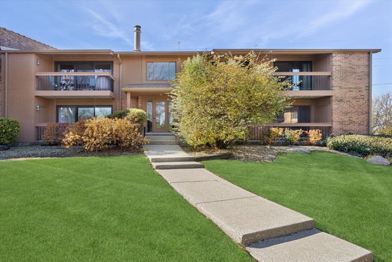 Front view of a multi-story building with balconies and a central entrance.
