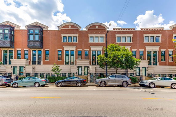 Front view of a multi-story brick building with large windows.