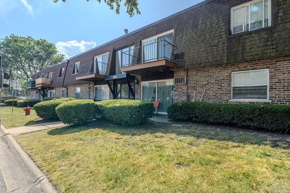 Front view of a two-story apartment building with brick exterior and balconies.