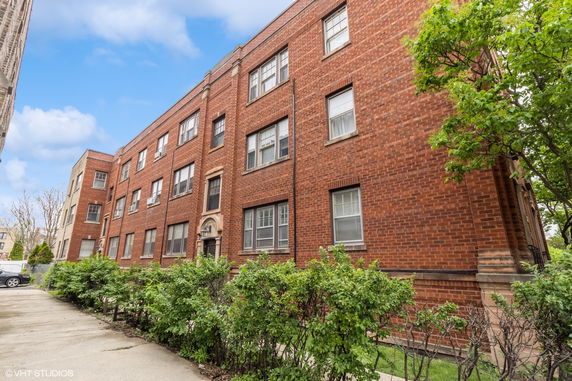 Front view of a three-story brick building with multiple windows.