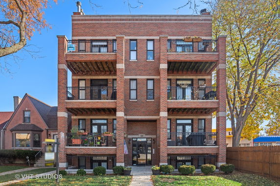 Front view of a multi-story brick building with balconies.