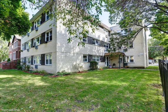 Front view of a three-story apartment building with a brick exterior.