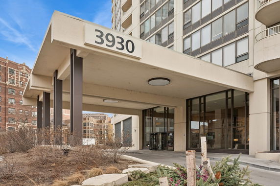 Front view of a multi-story building entrance with large glass windows.