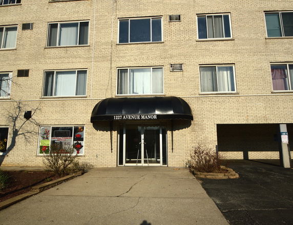 Front view of a multi-story apartment building with an entrance canopy.