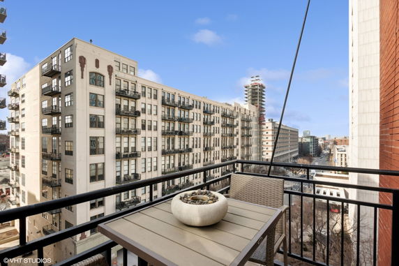 View from a balcony overlooking nearby buildings and a street.
