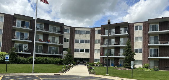 Front view of a multi-story apartment building with balconies.
