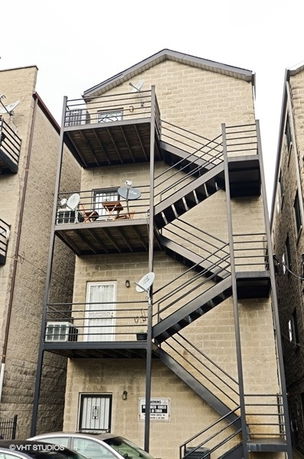 Front view of a multi-story building with external staircases and balconies.
