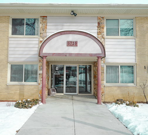 Front view of a building with a central entrance and two stories.