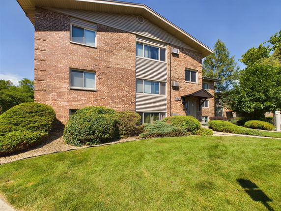 Front view of a brick apartment building with multiple stories.