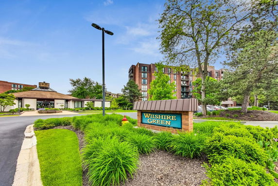 Front view of a residential building with multiple stories and a name sign in front.