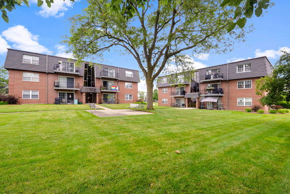 Front view of a three-story apartment building with brick exterior and balconies.