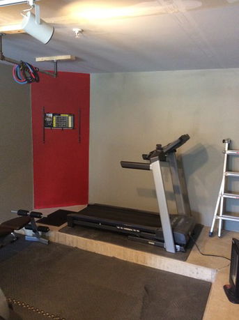 Indoor gym area with treadmill and exercise equipment.