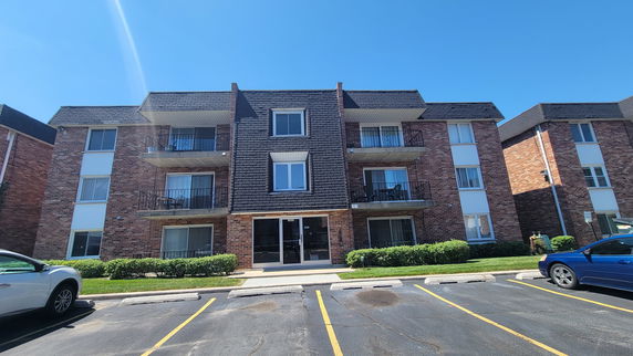 Front view of a three-story apartment building with balconies.