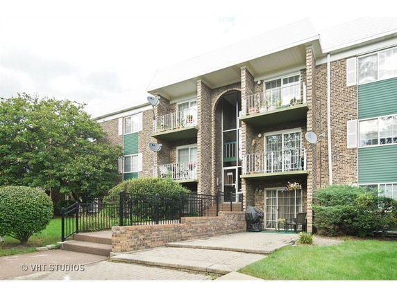 Front view of a multi-story apartment building with balconies.