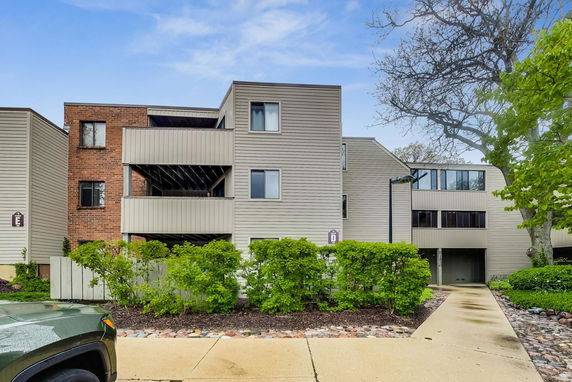 Front view of a multi-story building with a mix of brick and siding exterior.