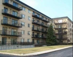 Front view of a multi-story apartment building with balconies.