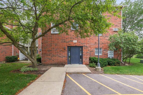 Front view of a brick residential building with a dark blue door.