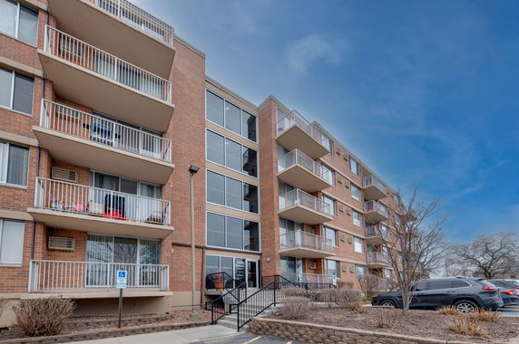 Front view of a multi-story apartment building with balconies.