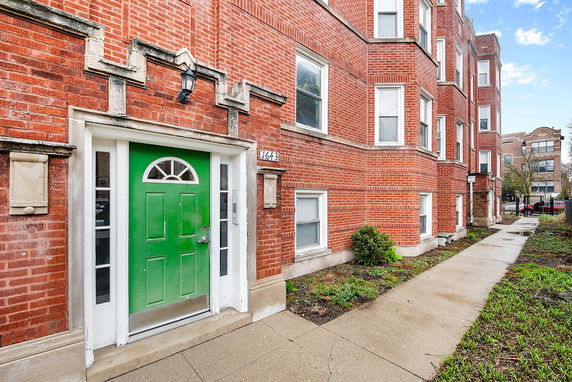 Front view of a brick building with a prominent green door.