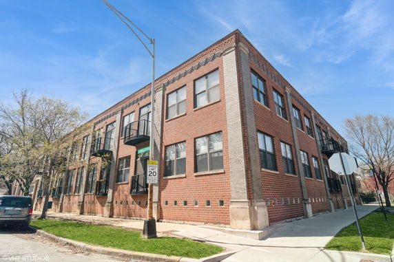 Front view of a brick apartment building with multiple windows and balconies.