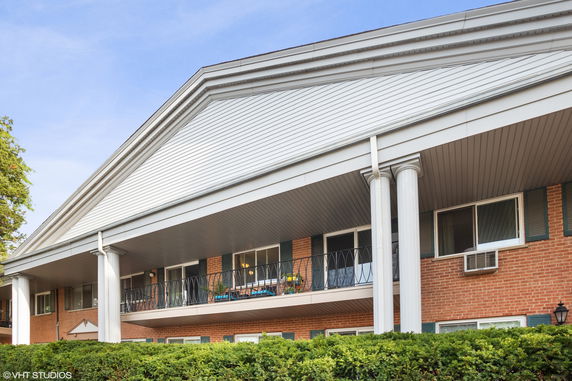 Front view of a two-story building with columns and balconies.