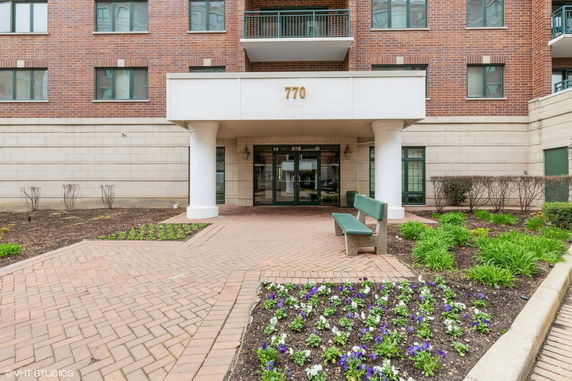 Front view of a multi-story residential building with a brick exterior and entrance.
