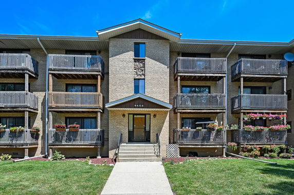 Front view of a multi-story apartment building with balconies.