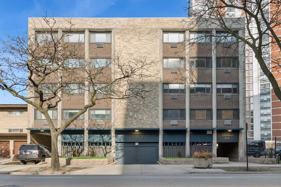 Front view of a multi-story building with brick facade and windows.