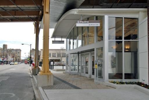 Front view of a modern glass entrance to a building with signage indicating a station.