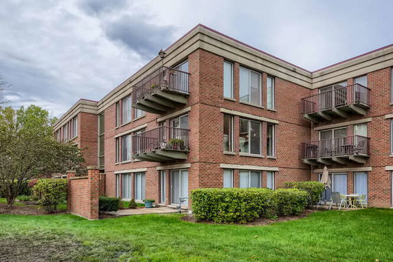 Front view of a multi-story brick apartment building with balconies.