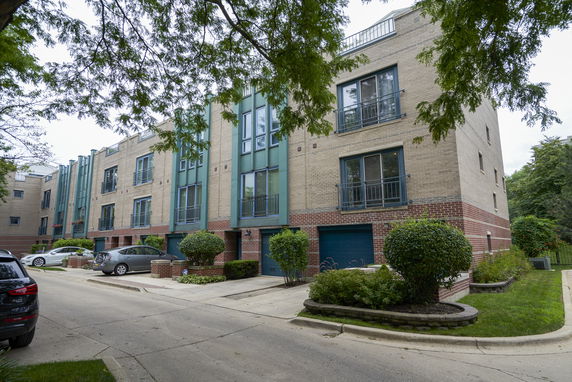 Front view of a multi-story residential building with garage entrances.