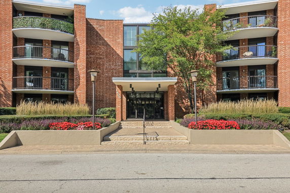Front view of a multi-story building with balconies and brick exterior.