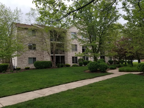 Front view of a multi-story residential building with brick exterior and multiple windows.